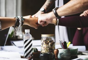 5 hands fist bumping over a conference table