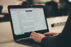A person typing to add text content to their business website.